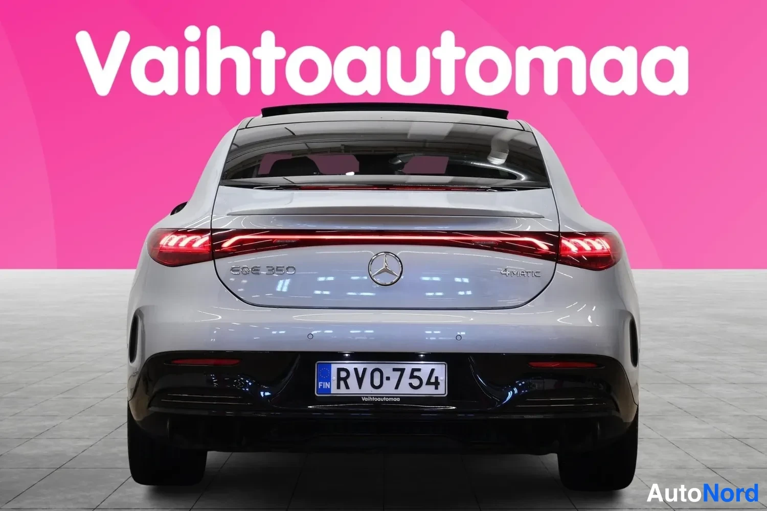 Takaa: Auton takaosakuva suoraan takaa: hopeanvärinen Mercedes-Benz EQE 350, kuluvat takavalot ja rekisterikilpi RV0-754.