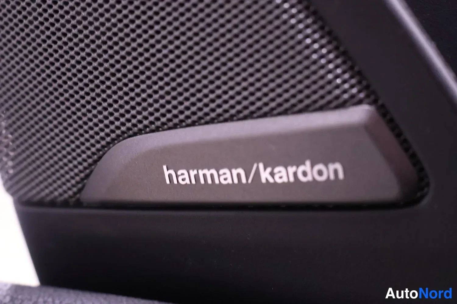 Edestä: Nearview kuvaa mustasta BMW iX3:n HARMAN/KARDON-kaiuttimesta, jossa on selkeä HARMAN/KARDON-merkintä.
