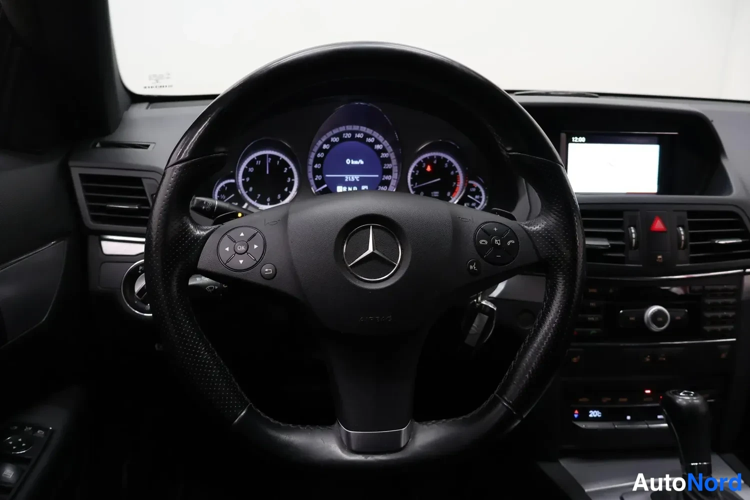 Muu: Ohjauspyörä ja kojelauta Mercedes-Benzissä, mittaristo ja keskikonsolin näyttö näkyvät.