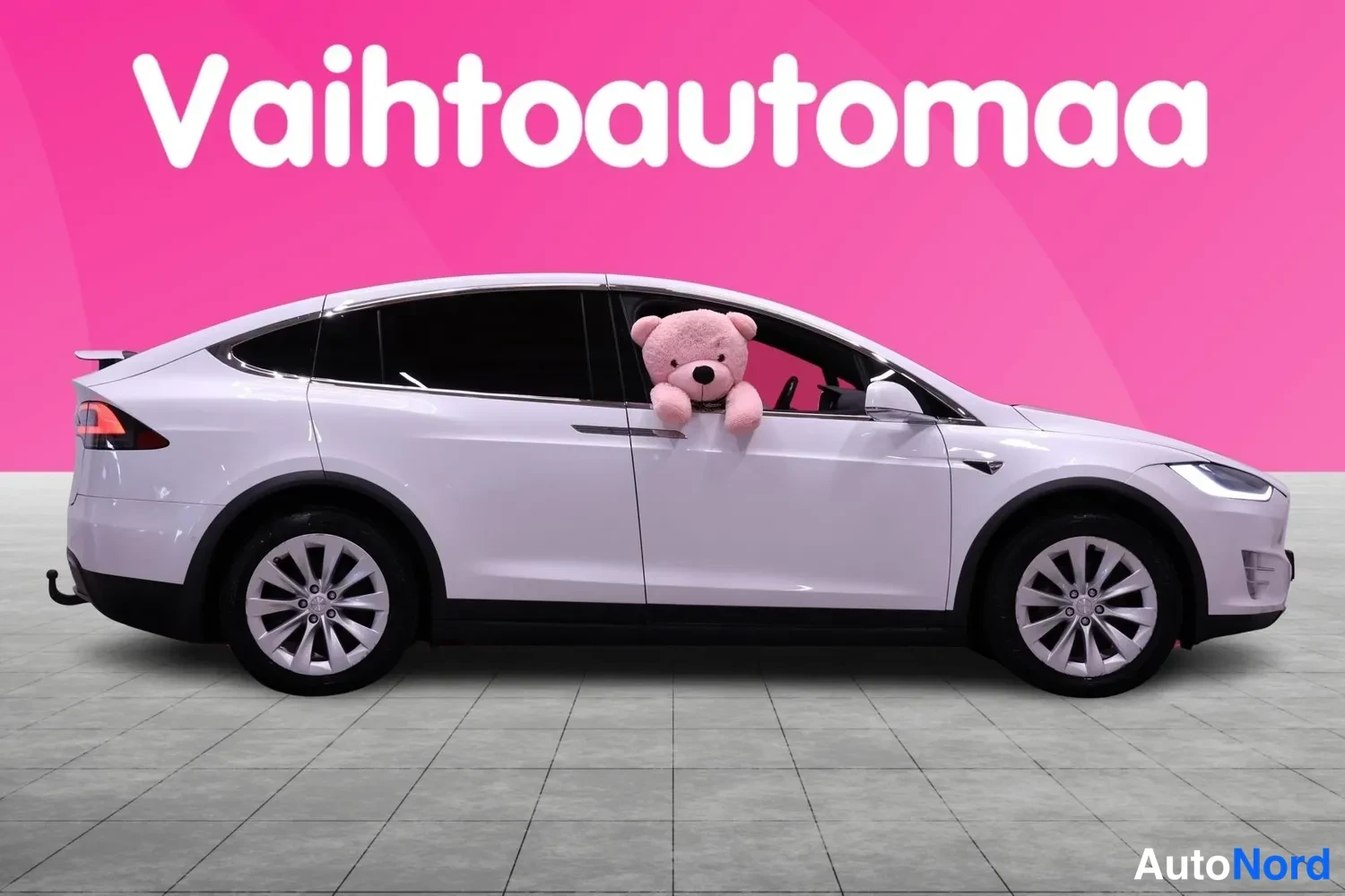 Sivulta: Valkoinen Tesla Model X sivulta oikealta katsottuna.