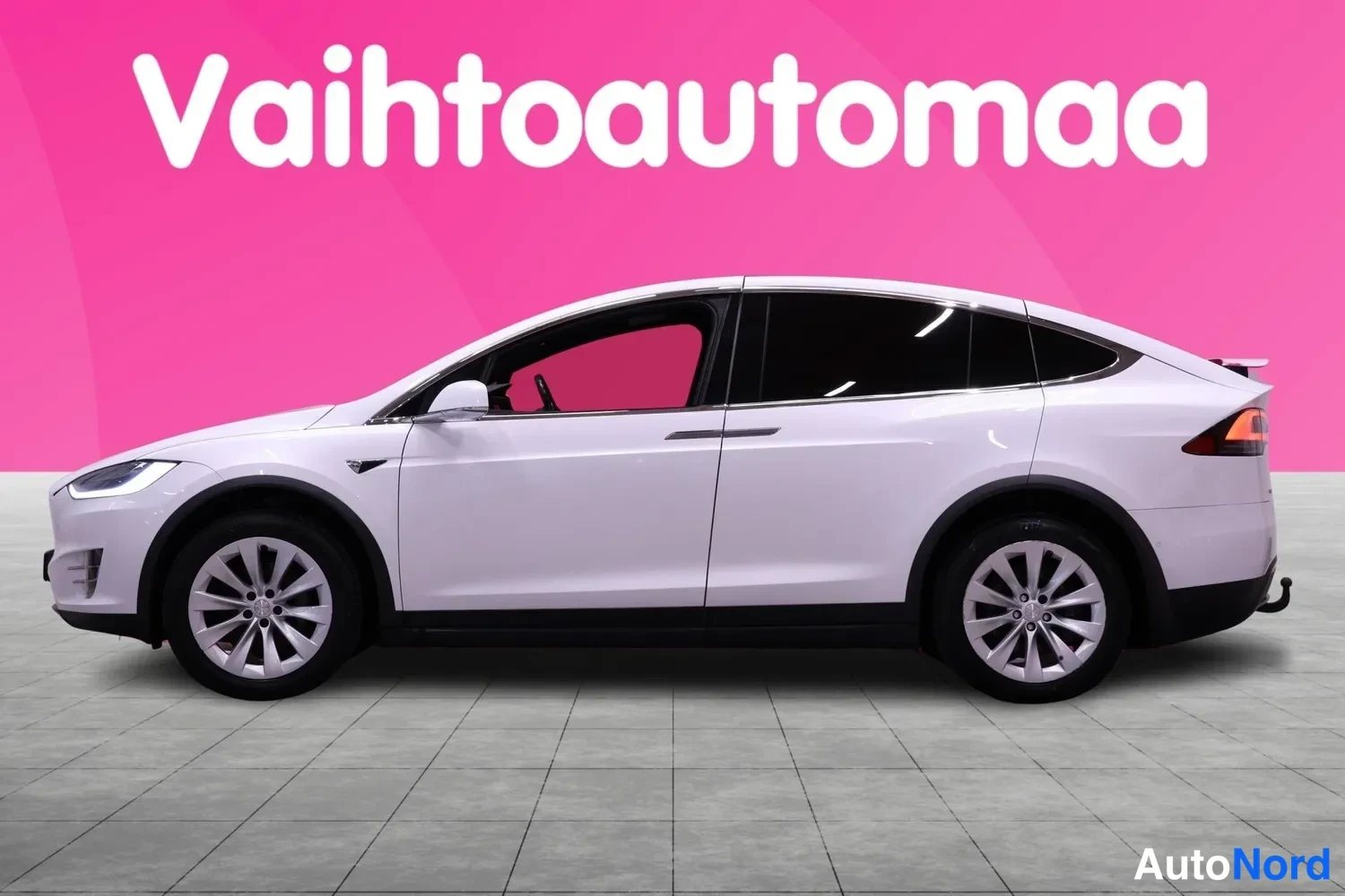 Sivulta: Tesla Model X -farmarin sivunäkymä, valkoinen koriväri, hopeiset vanteet ja tummennetut ikkunat näkyvät