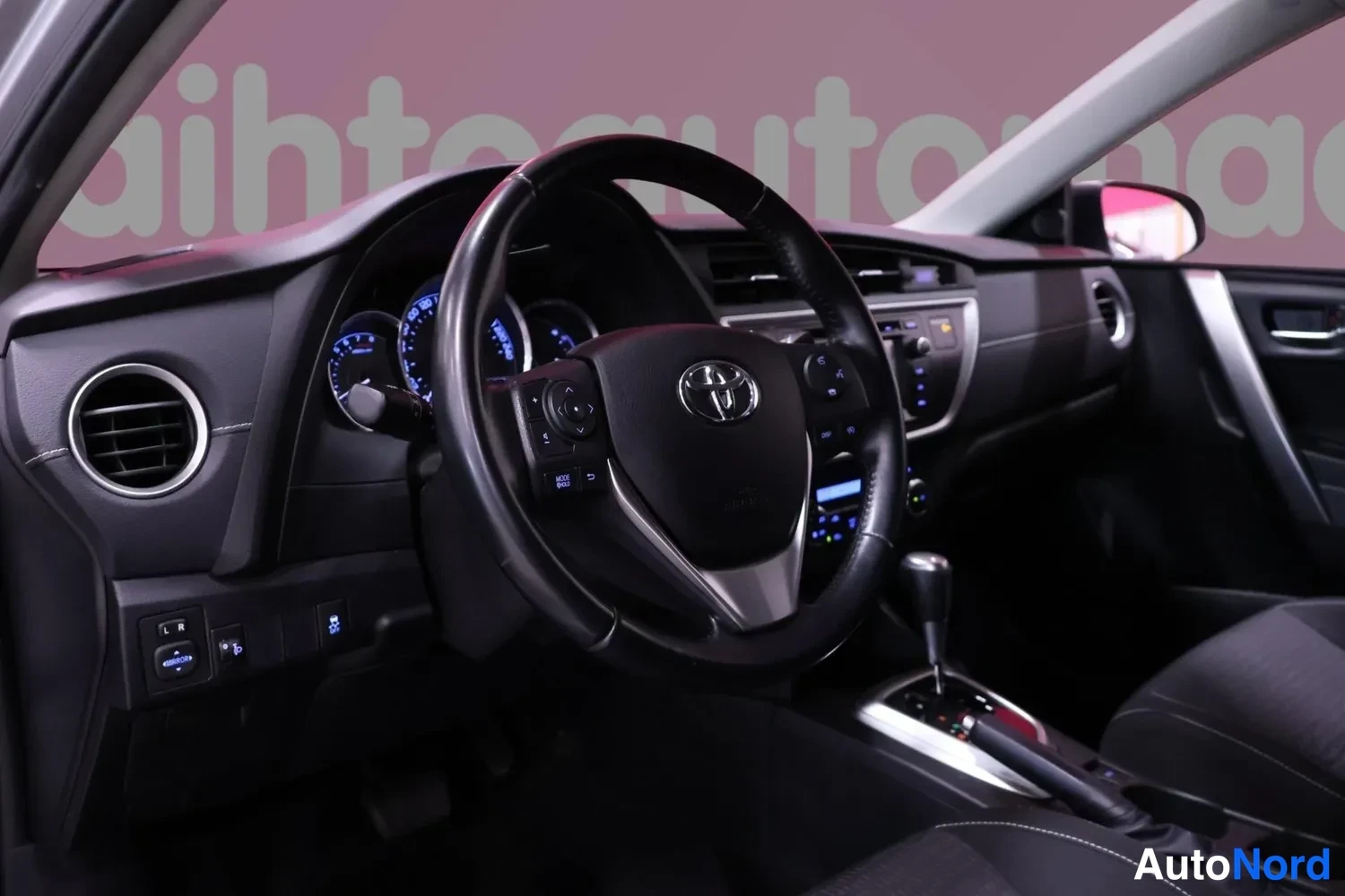 Muu: Ohjaamo kuljettajan puolelta: Toyota-ohjauspyörä, kojelauta ja automaattivaihteiston valitsin.