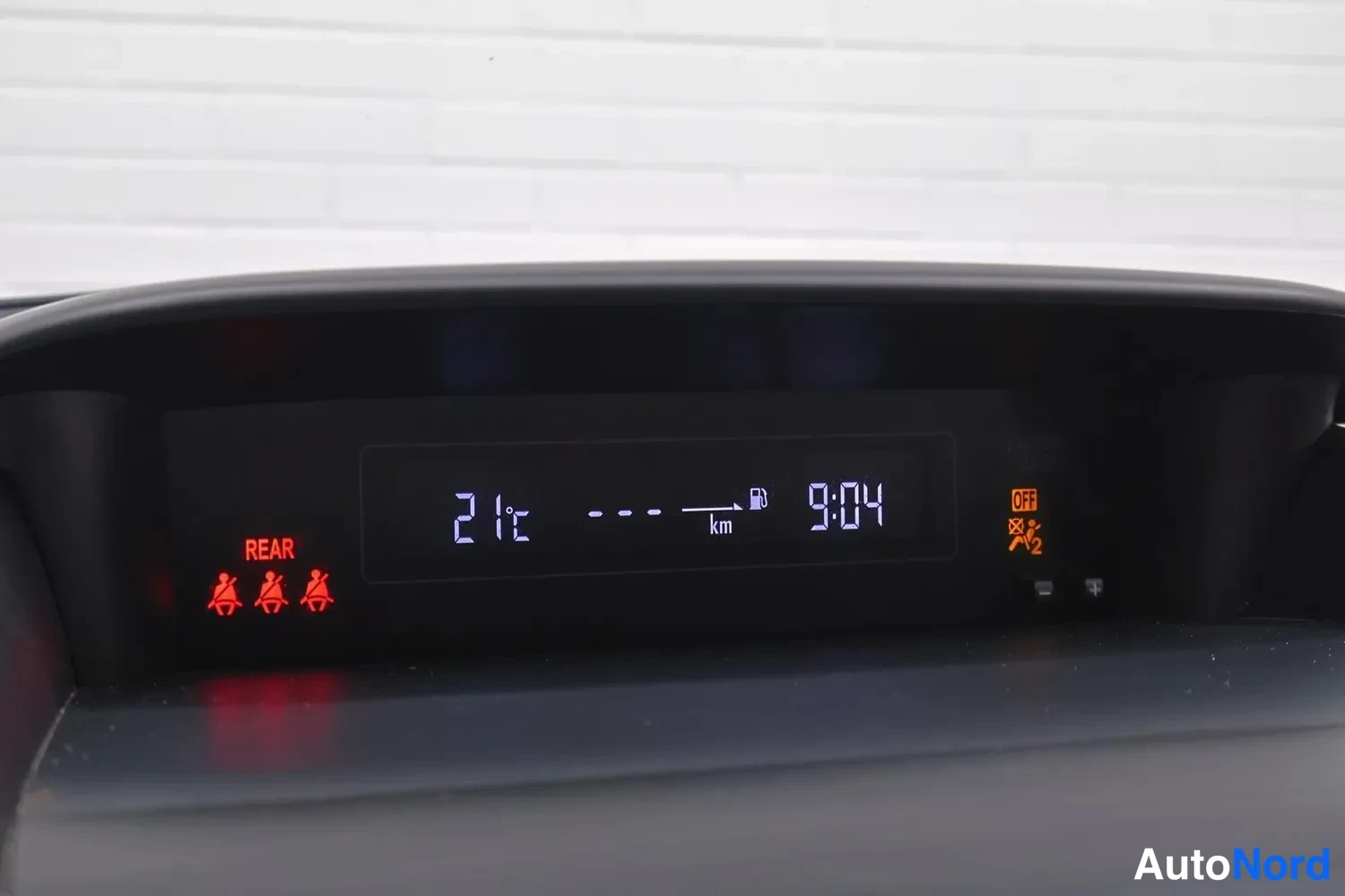 Muu: Kojelaudan ylänäyttö näyttää 21 °C lämpötilan, kellonajan 9:04 ja REAR-merkinnän.