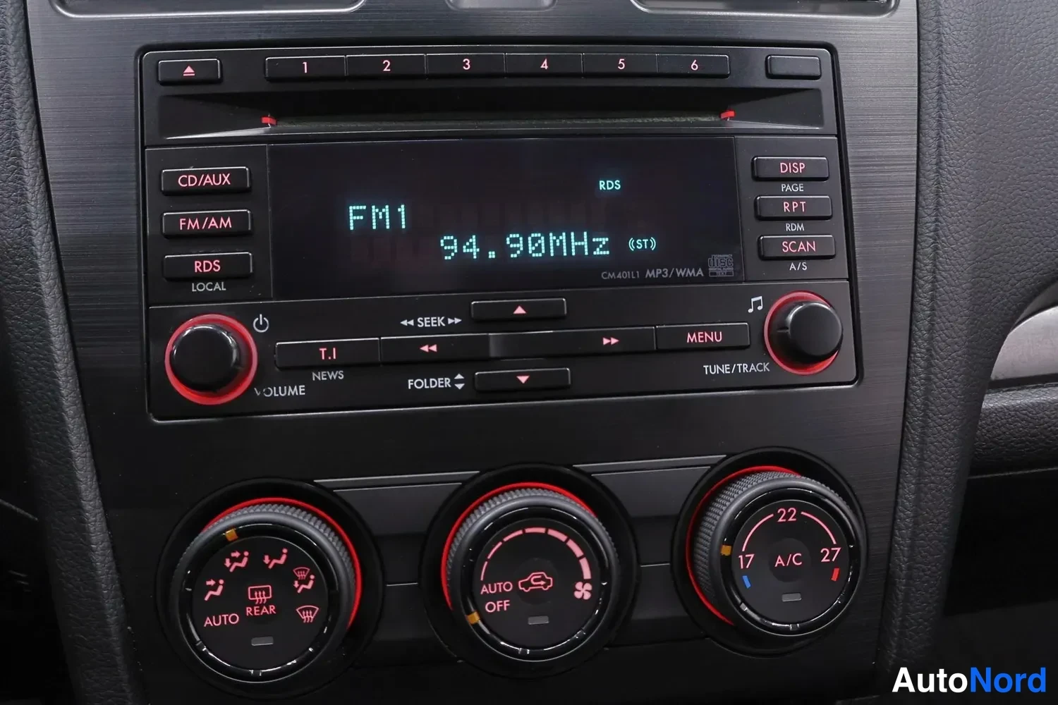 Yksityiskohta: Keskitunnelin radio- ja ilmastointipaneeli: näytöllä FM1 94,90 MHz, painikkeita CD/AUX, FM/AM ja RDS, alla kolme ilmastoinnin säätöpyörää, joissa merkit AUTO, O