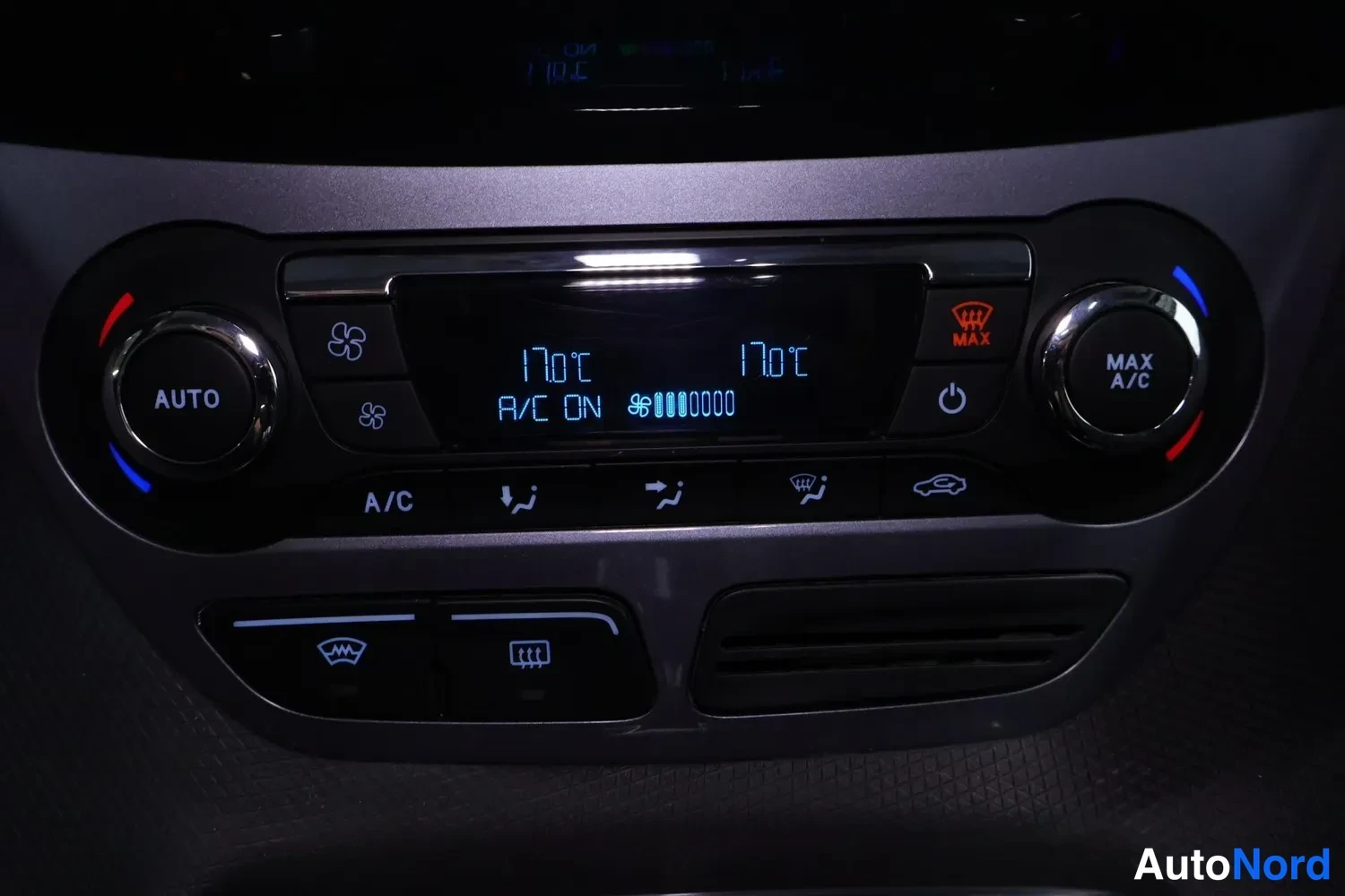 Muu: Auton ilmastointipaneeli, jossa AUTO- ja MAX A/C -säätimet sekä näytölukema 17°C ja teksti A/C ON.