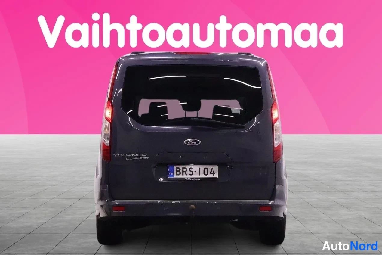 Takaa: Tummansinisen Ford Tourneo Connect -pakettiauton takaosa suoraan takaa, rekisterikilpi ja Takavaloa palaa.