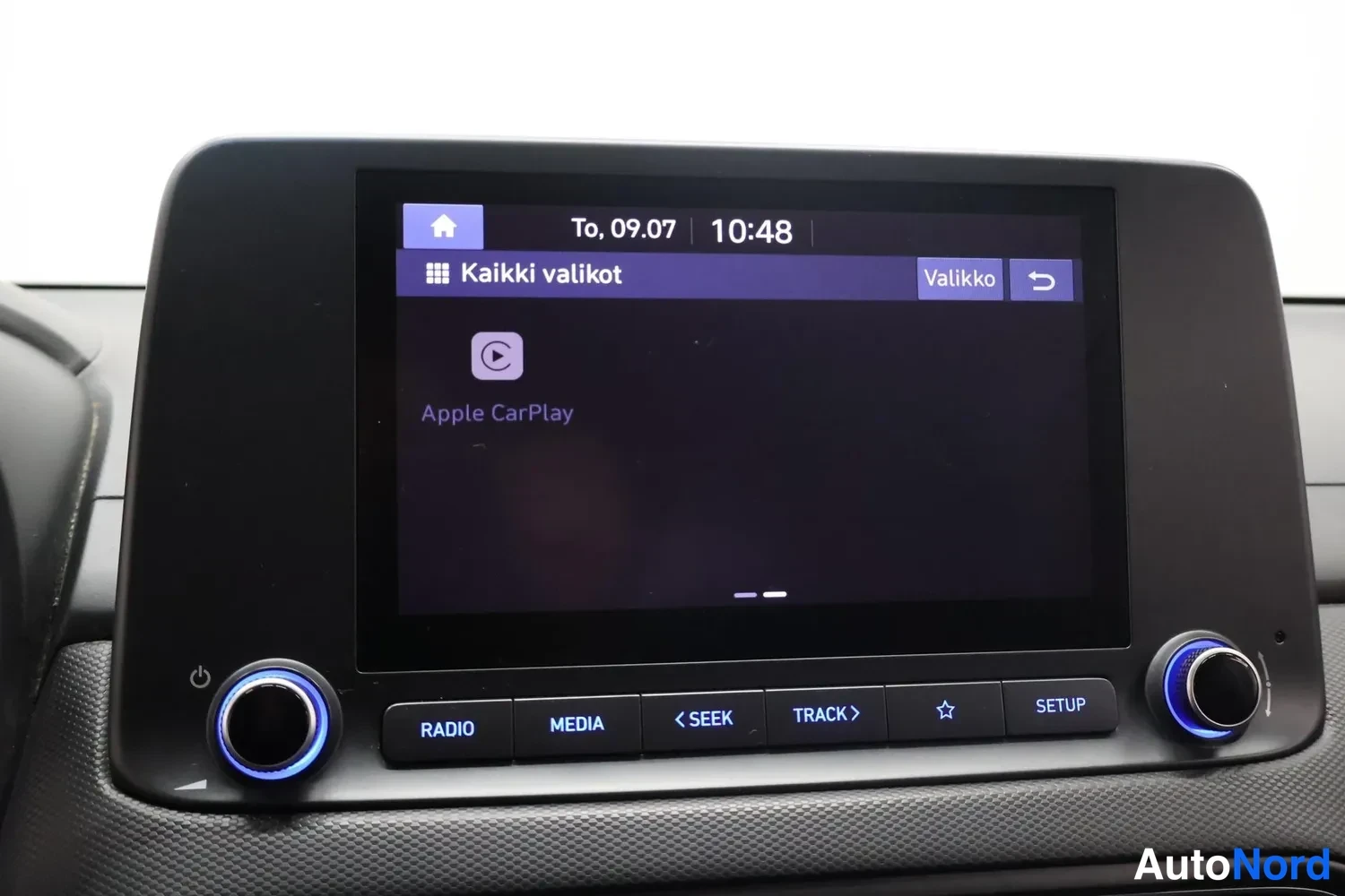 Muu: Auton kojelaudan kosketusnäyttö näyttää Apple CarPlay -kuvakkeen ja valikon Kaikki valikot, alla napit Radio, Media, Seek ja Setup.