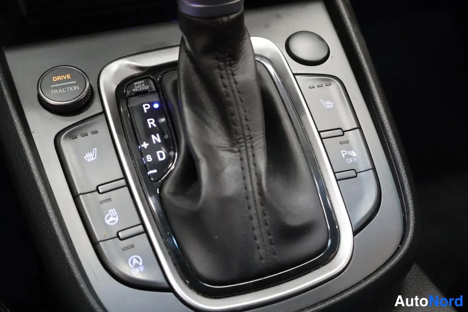 Muu: Auton keskikonsolin vaihteenvalitsin P-asennossa, ympärillä napit kuten Drive/Traction, kauko- ja parkkitöpselit.