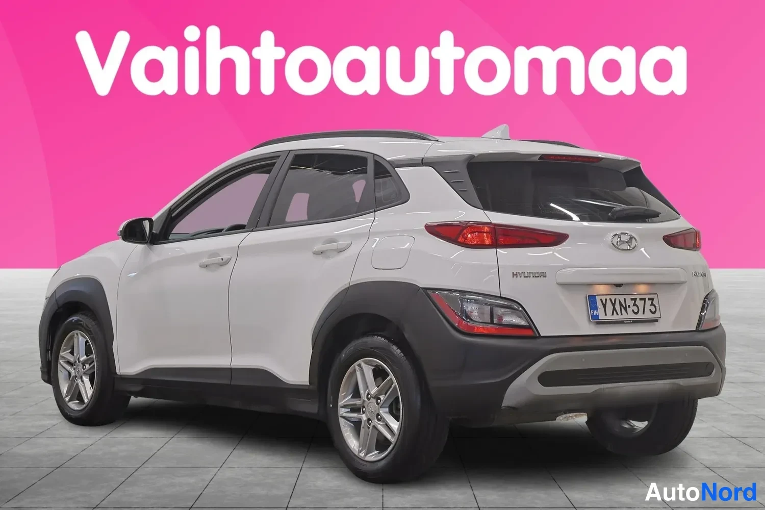 Takaviisto: Valkoisen Hyundai Kona -henkilöauton takakulma, rekisterikilpi näkyvissä.