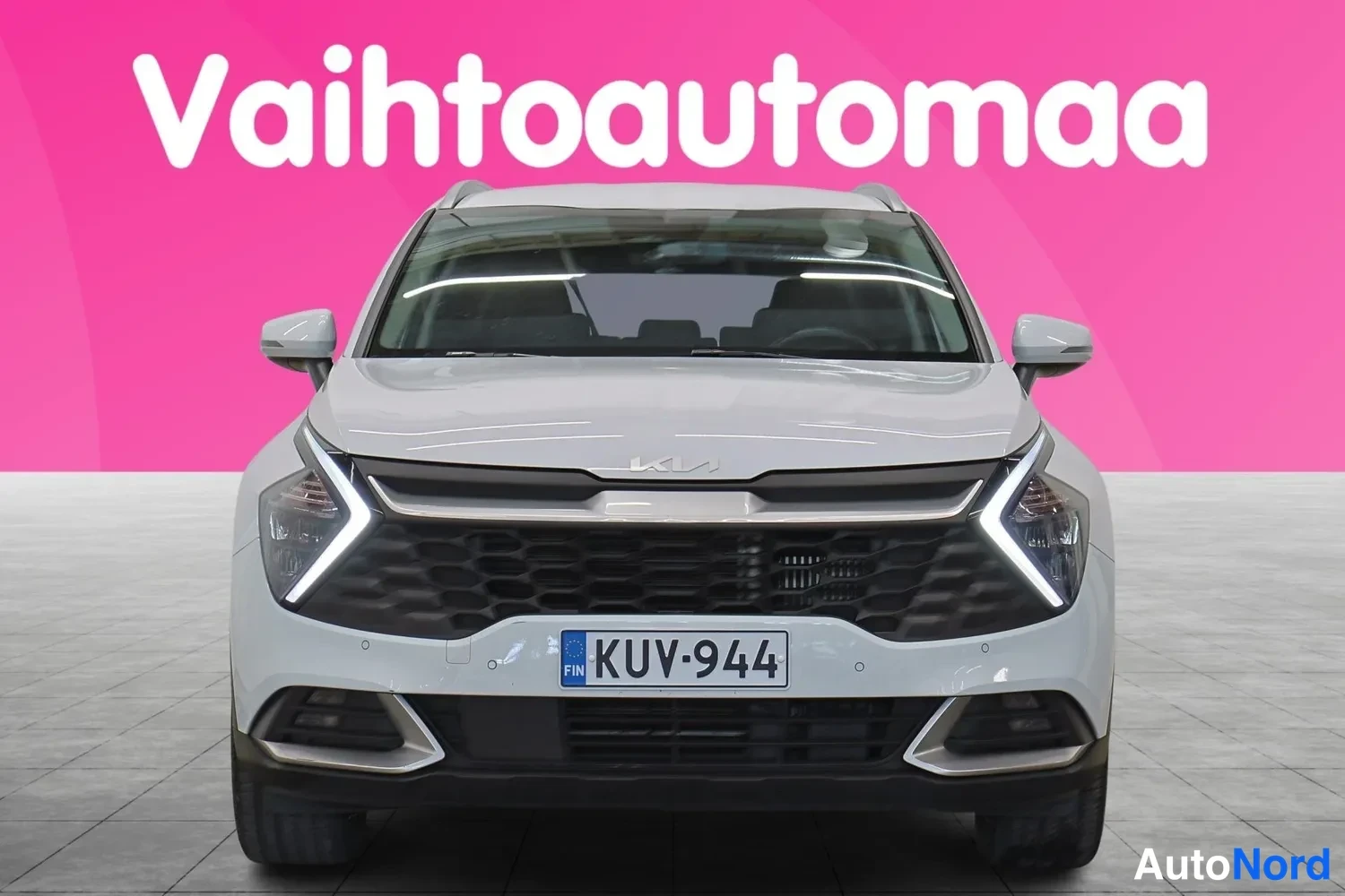 Edestä: Valkoisen Kia Sportagen suora etunäkymä; Nokian etusäleikkö, SUV-tyyliset ajovalot ja rekisterikilpi näkyvät.