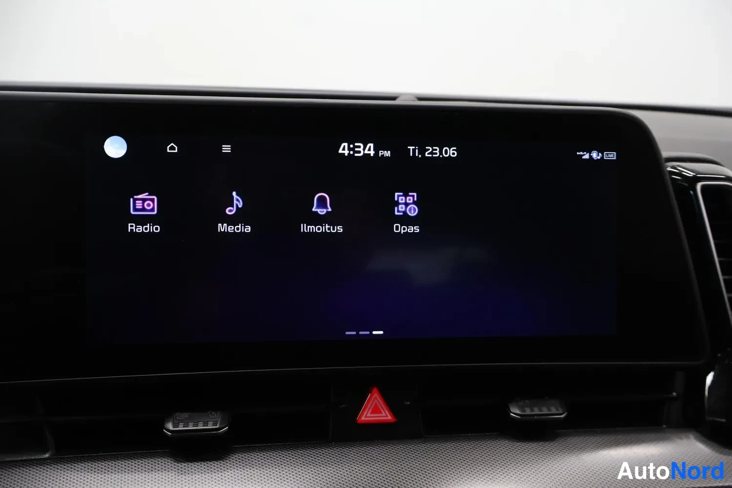 Yksityiskohta: Auton infotainment-näyttö näyttää valikossa Radio, Media, Ilmoitus ja Opas -toiminnot; kello 4:34 PM Ti 23.06.