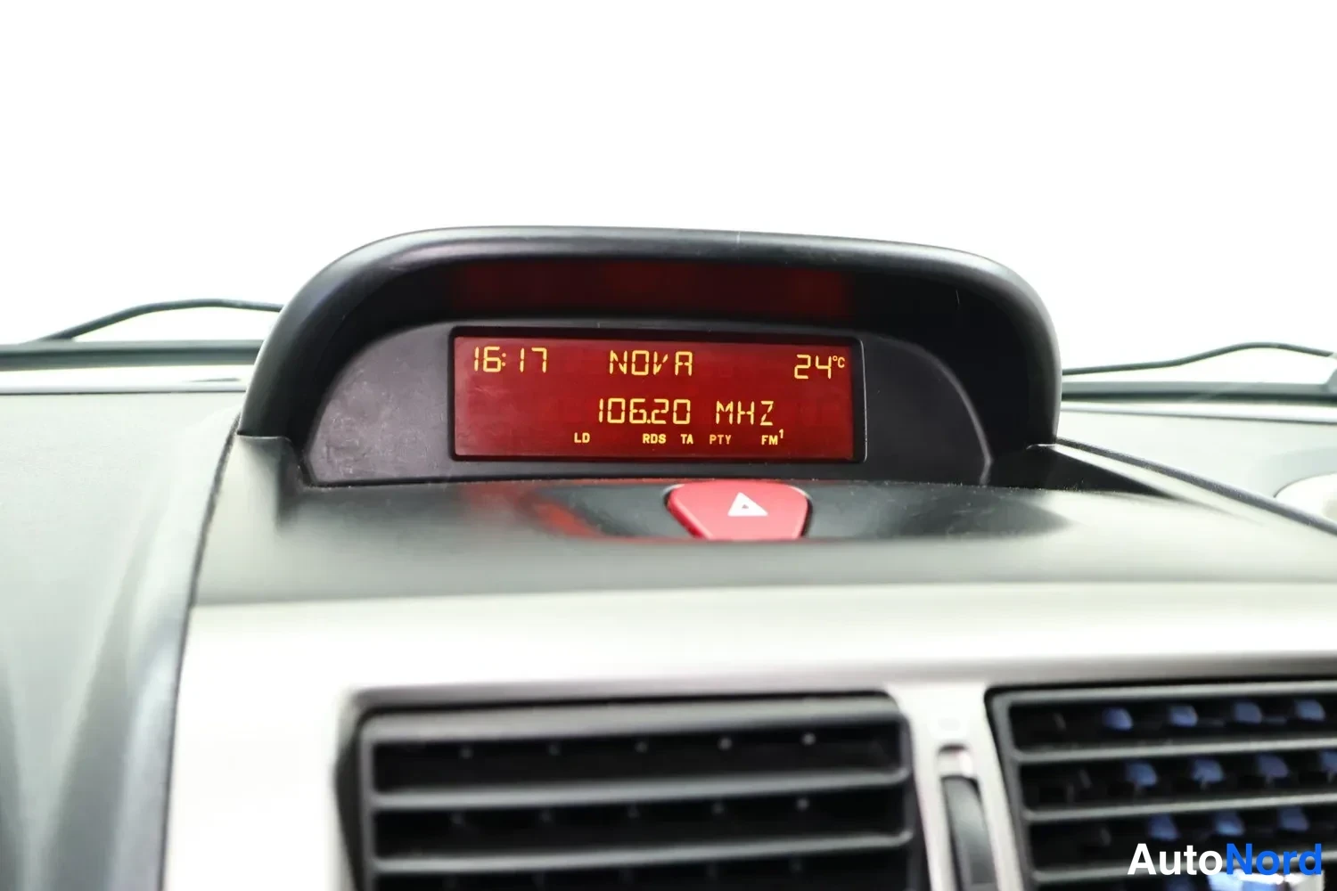 Muu: Kojelaudan yläosassa oleva infonäyttö näyttää kellonajan 16:17, kanavan NOVA, lämpötilan 24°C ja taajuuden 106.20 MHz.
