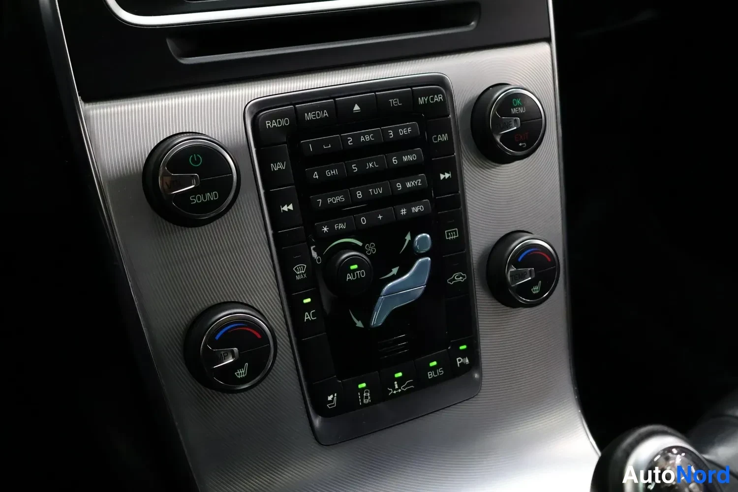 Yksityiskohta: Kojeiston keskiössä olevat radiokaiutin- ja ilmastointipainikkeet, joissa näkyy AC, AUTO, BLIS ja P-merkit.