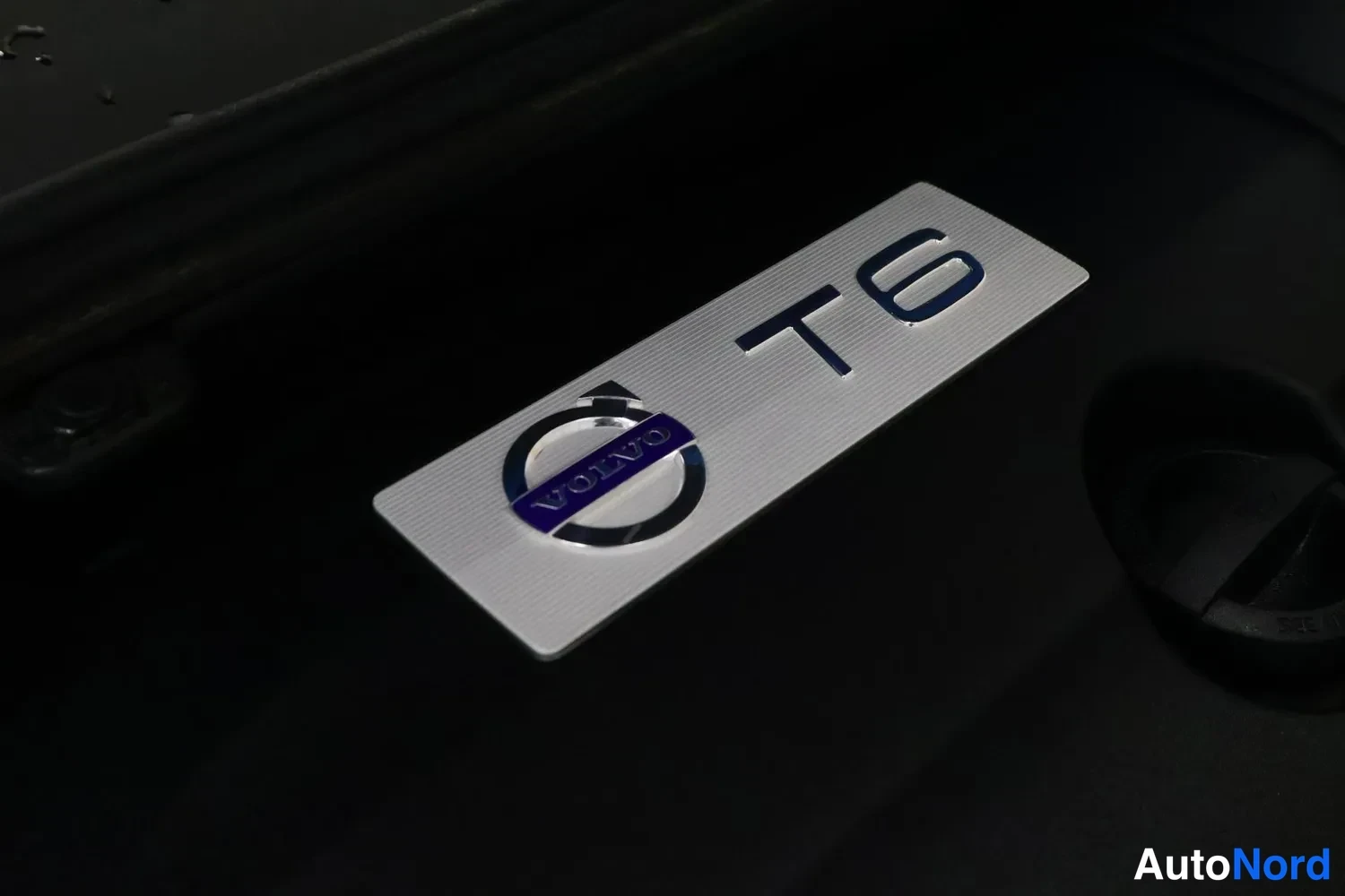 Yksityiskohta: Volvo T6 -merkintä hopeisella moottoritilan koristekilvellä.
