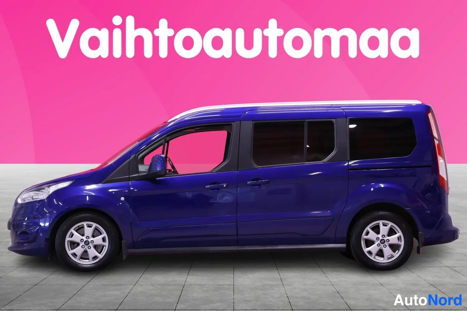 Sivulta: Sivuaukio valkokorkeassa Ford Tourneo Connect -pakettiautosta, tummanpunainen takaseinä ja kaksisuuntainen etuovi. Kaksi pyörää näkyvissä, rengasreunat ovat hop