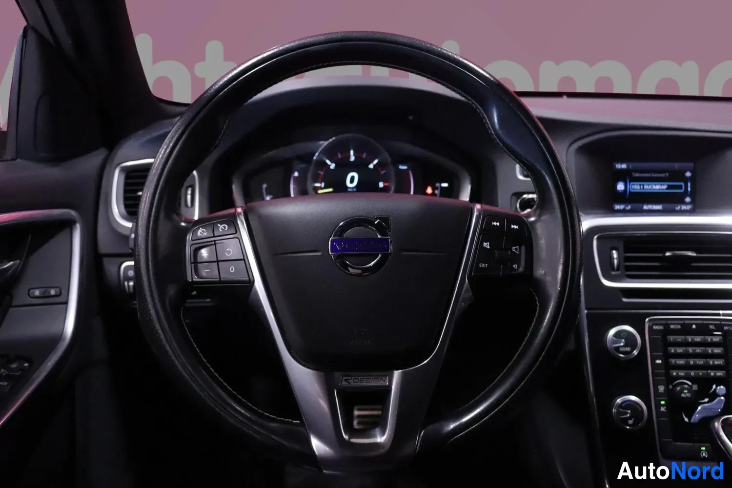 Muu: Volvo-merkillinen ohjauspyörä lähikuvassa, R-DESIGN-teksti pyörän alaosassa.