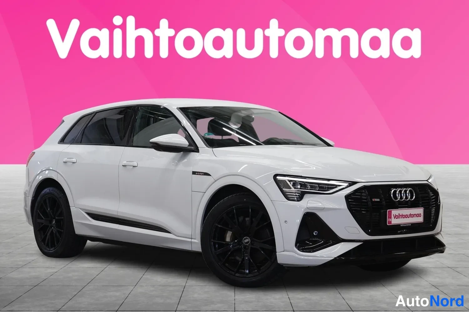 Etuviisto, nokka oikealle: Valkoinen Audi e-tron -maasturi kuvattu kolmestionurkkisesti edestä oikealta, mustat vanteet ja musta etusäleikkö