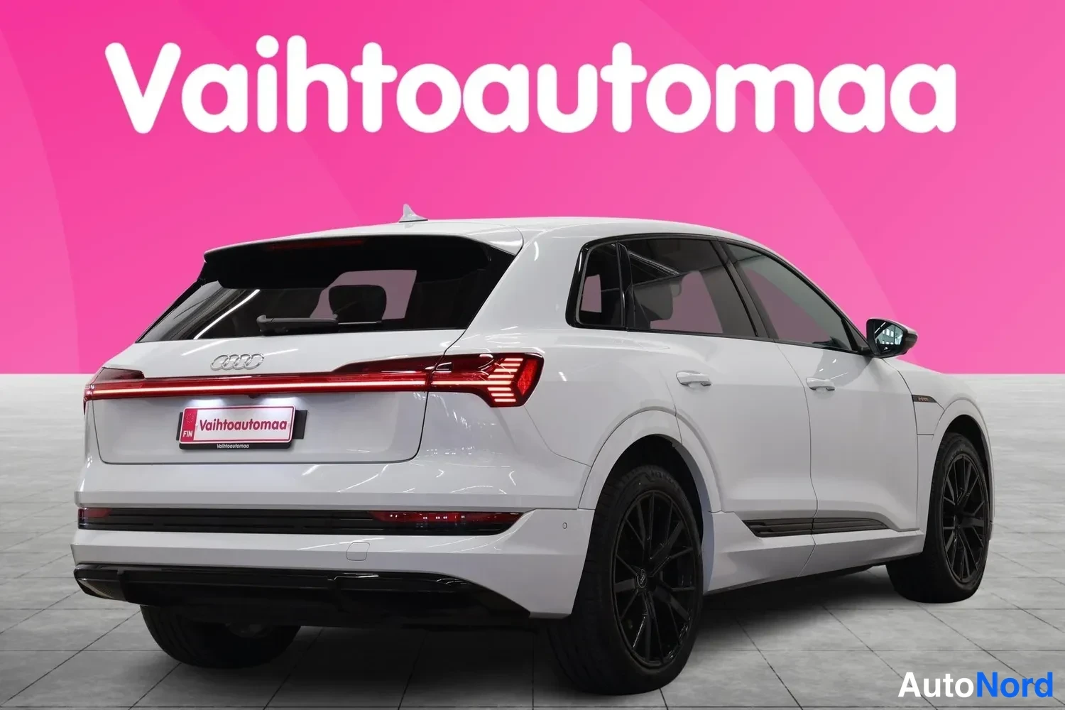 Takaviisto: Valkoinen Audi kolmesta neljäsosasta takaa vasemmalta, tummat valuvarret ja punainen takavalojensauma.