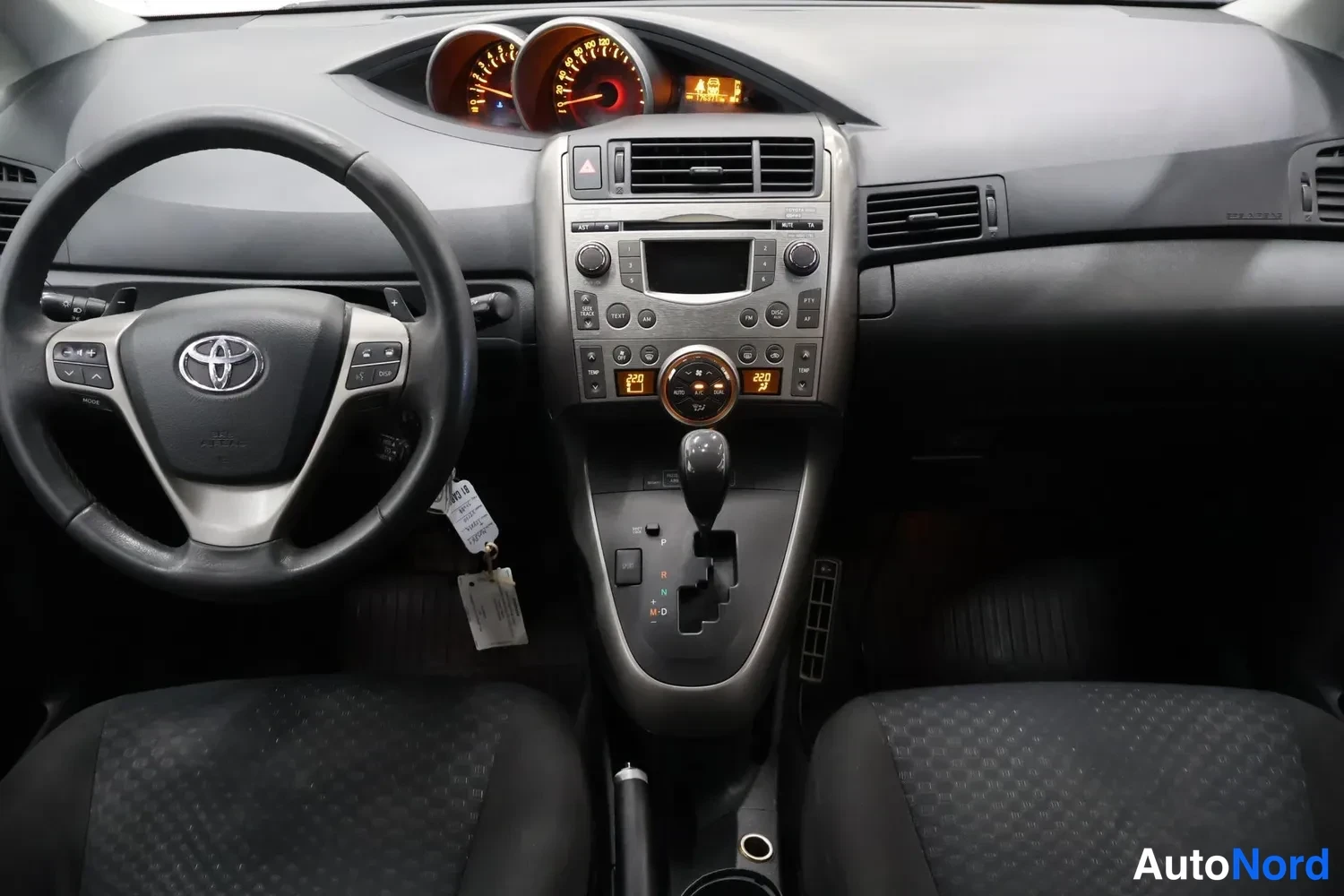 Muu: Kohtelusuhdekojelauta: Toyota-ohjauspyörä, analogiset mittarit, keskikonsolin radio, automaattivaihteen valitsin P-R-N-D-M-D-merkilila ja tummat istuimet.