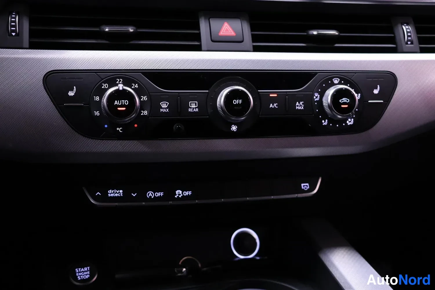 Muu: Kojelaudan ilmastointipaneeli AUTO-ruuvilla, lämpöasteikko 16–28 °C, A/C- ja A/C MAX-nappulat, OFF-ruuvi sekä alla drive select -painikkeet ja START ENGINE STOP