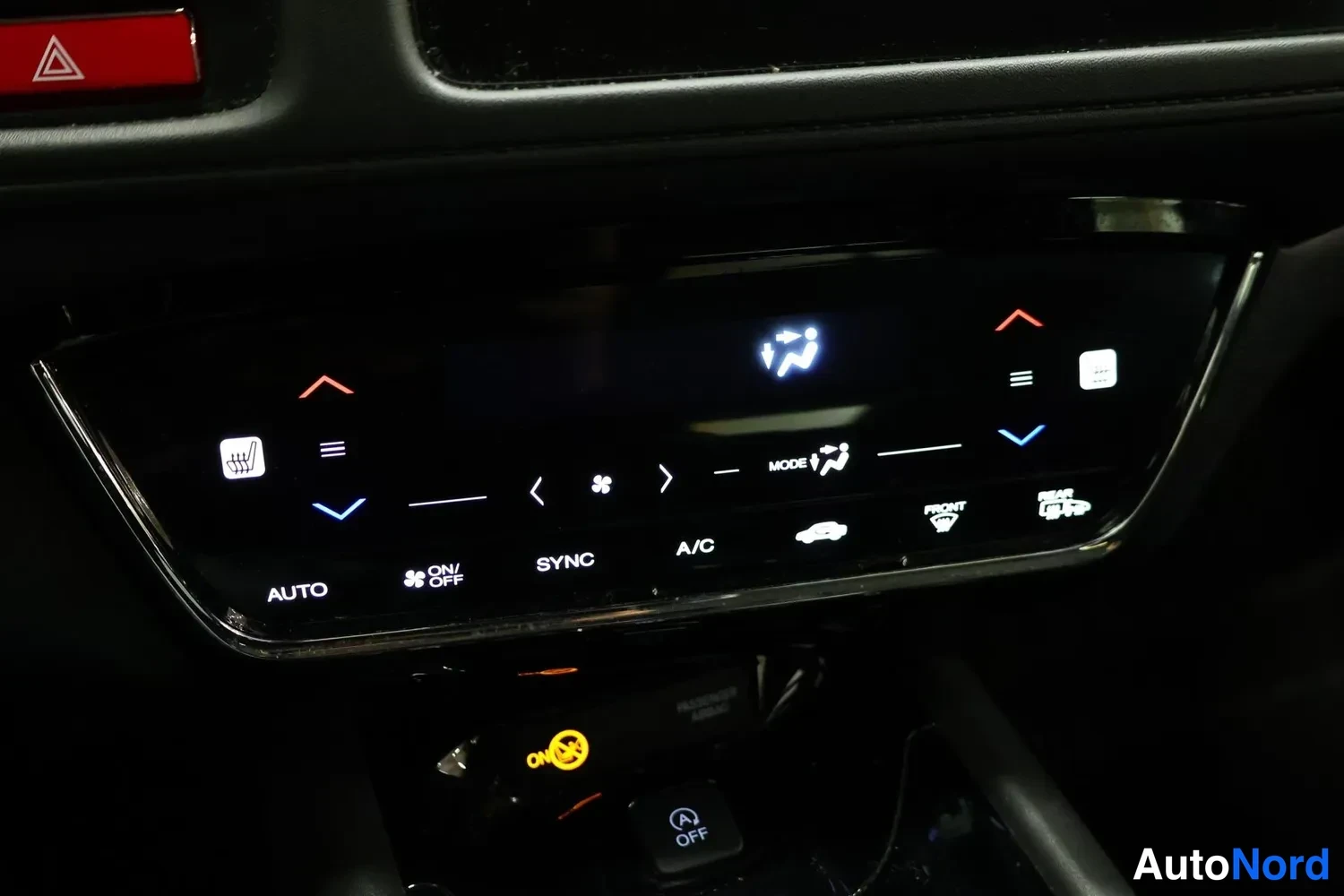 Yksityiskohta: Auton automaattisen ilmastoinnin keskuskonsoli, jossa näkyvät AUTO-, SYNC- ja A/C-napit sekä濒 tuuletus- ja lämmitystoiminnot.