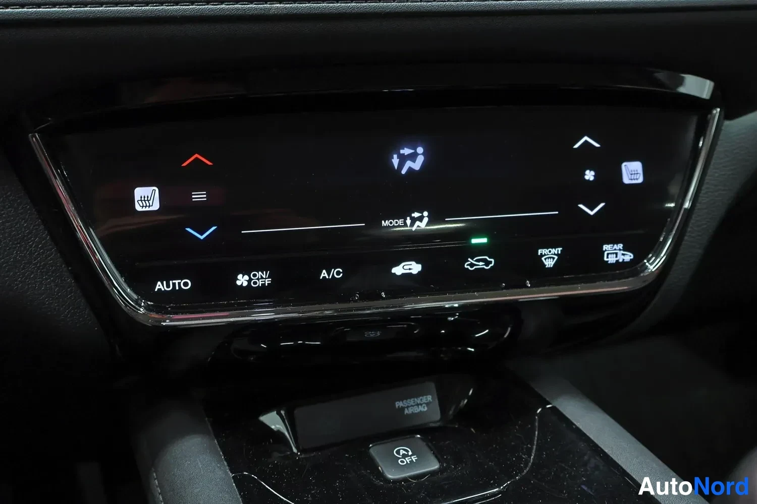 Muu: Auto ilmastointipaneeli, jossa napit AUTO, A/C ja tuulilasin lämmitys.