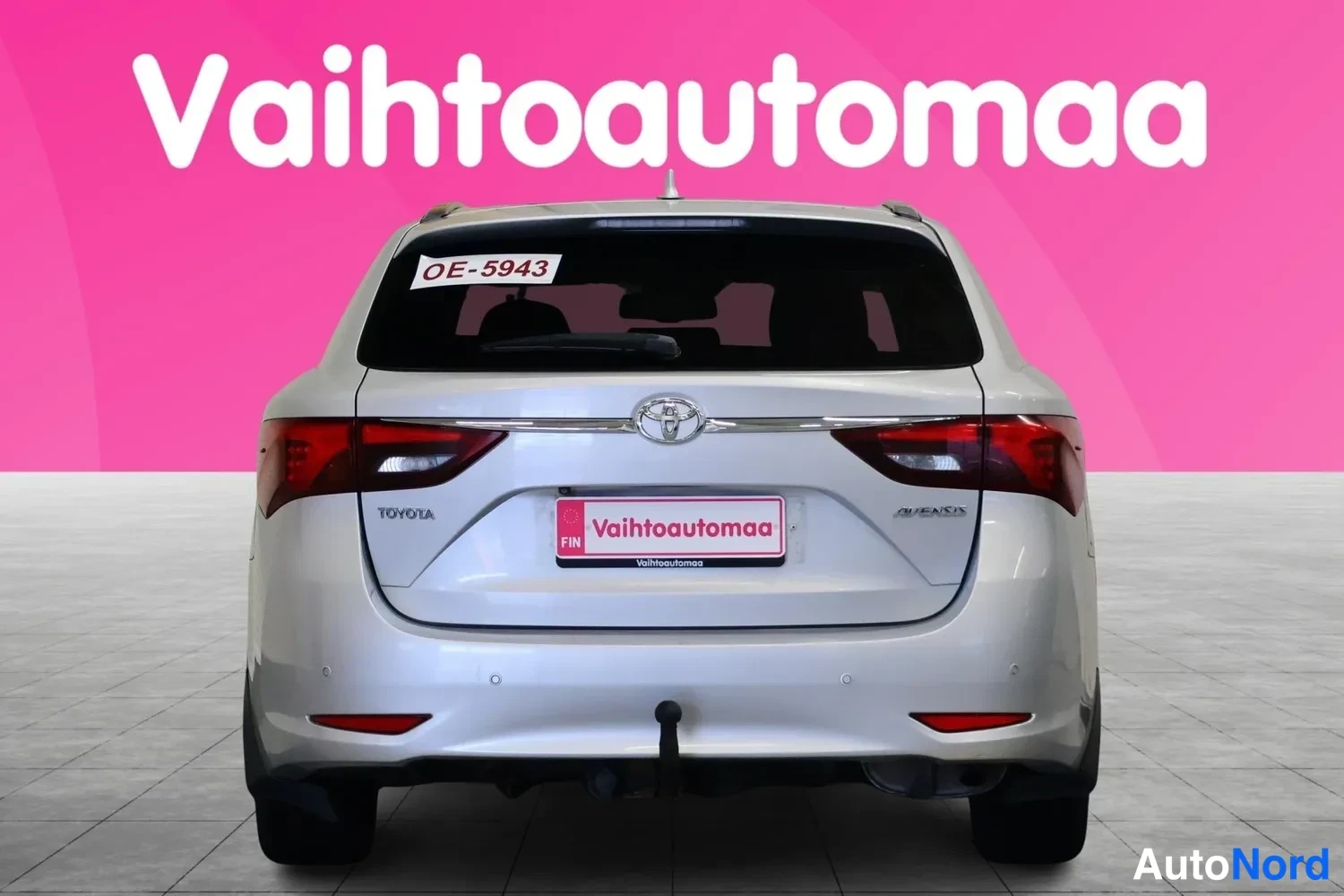 Takaa: Toyota Avensis station wagon rear view, boot lid with Toyota badge, Toyota and Avensis badges, registration plate OE-5943, trailer hitch