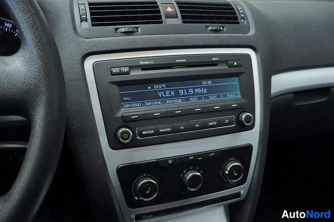 Yksityiskohta: Keskikonsolin Škoda Swing -radio näyttää VLEX 91.9 MHz ja lämpötilan 24,5 °C, alla AC-painike ja lämmityksen säätönupit.