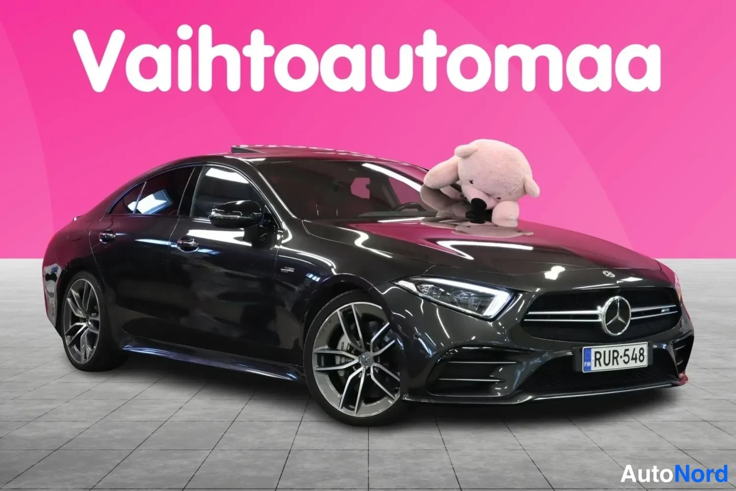 Etuviisto, nokka oikealle: Tummanharmaan Mercedes- CLS -coupén etunurkka oikealta kuvattuna, AMG-koriin pakkilla ja monitoimivanteilla.
