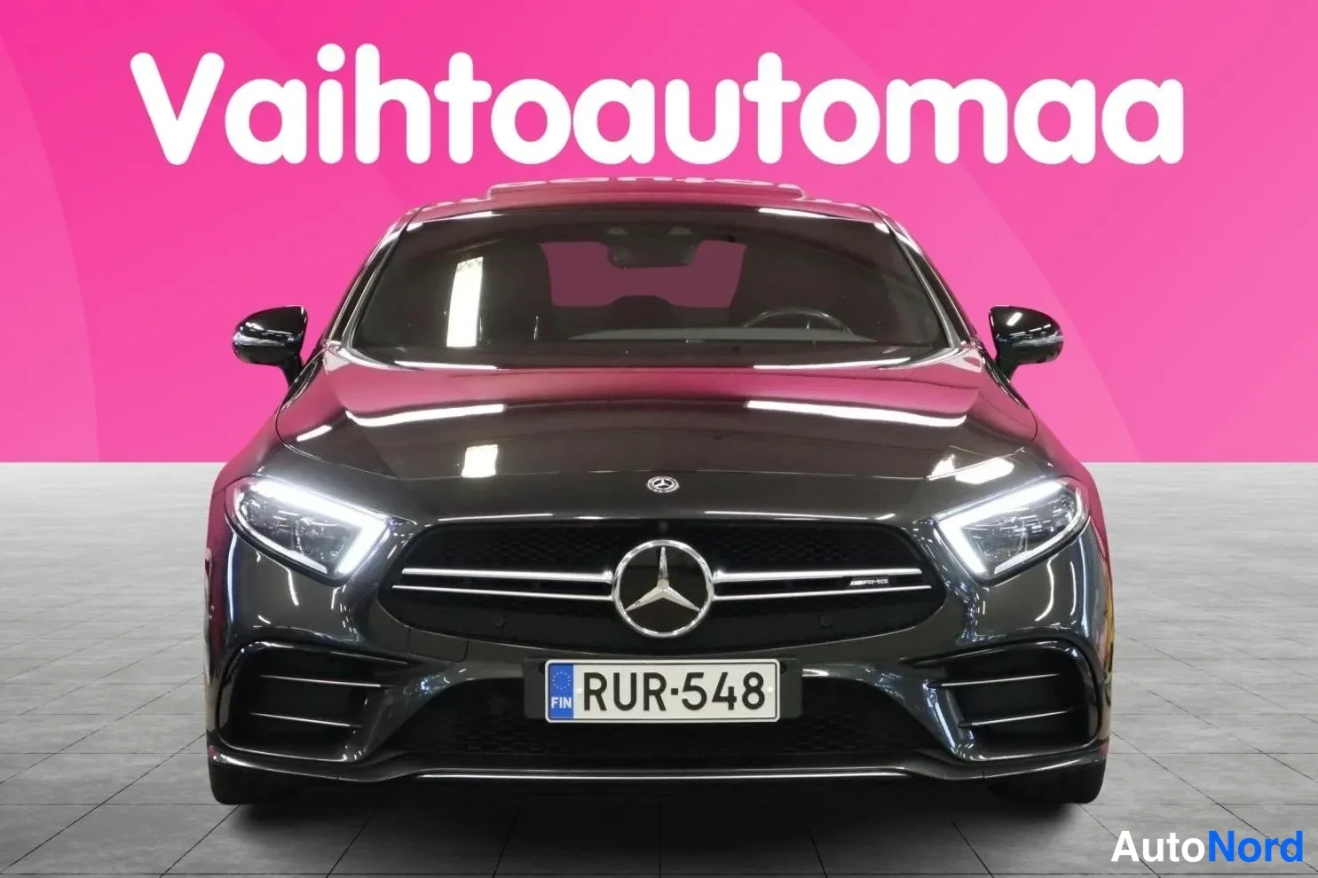 Edestä: Tummanharmaan Mercedes- CLS -coupén etunäkymä AMG-korilla, täysledi-alueilla ja -rekisterillä.