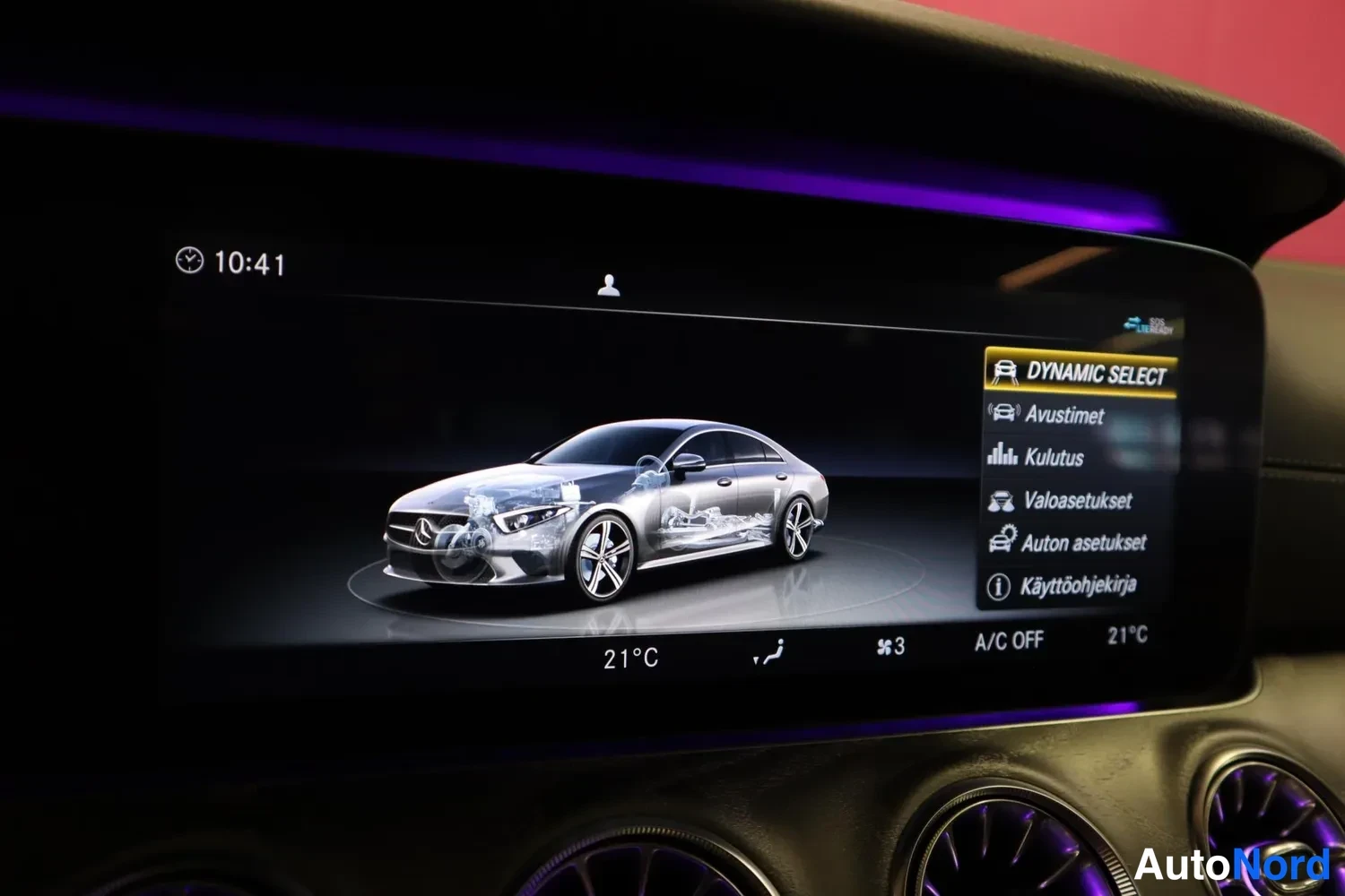 Muu: Infotainment-näyttö DYNAMIC SELECT-valikossa ajoneuvon kuvalla, valikossa Avustimet, Kulutus, Valoasetukset, Auton asetukset ja Käyttöohjekirja.