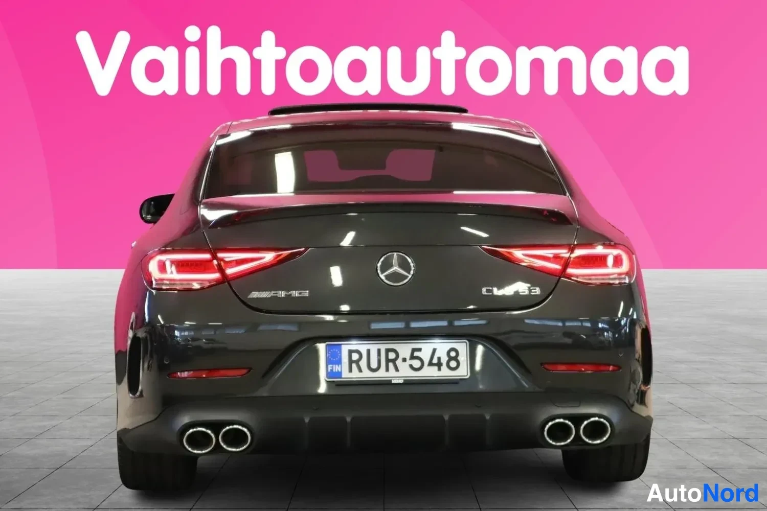 Takaa: Auton takaosa suoraan takaa: tumma Mercedes-Benz AMG CLS 53, Siniset rekisterikilvet, kaksinkertaiset pakoputket molemmin puolin.