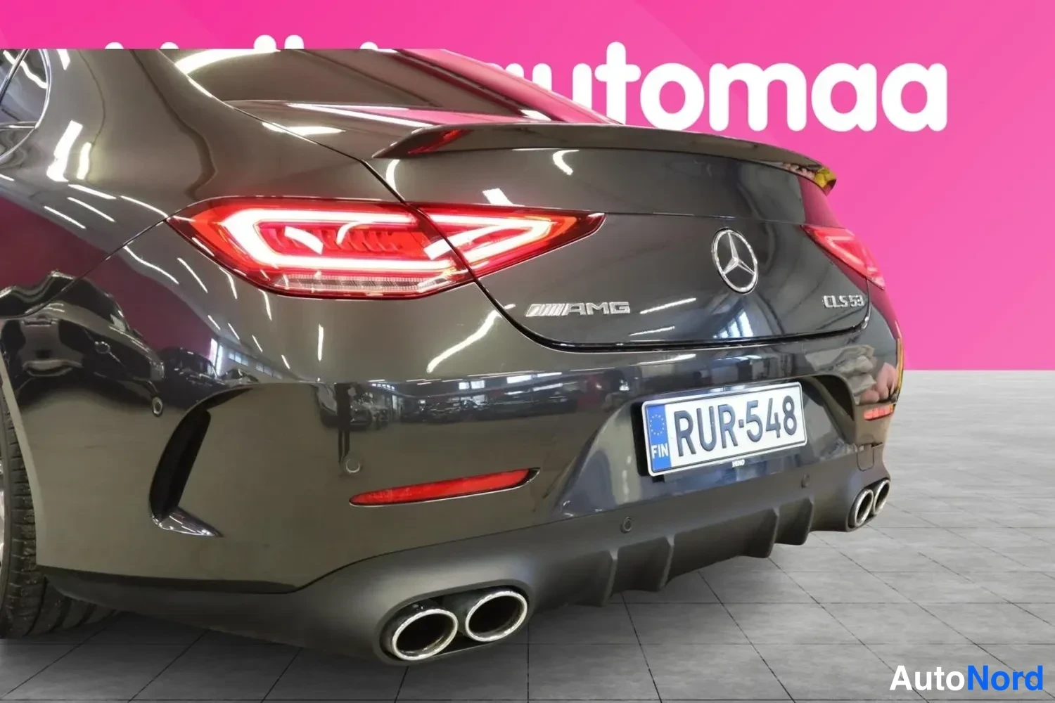 Takaviisto: Lähikuva auton takapäästä: AMG CLS 53 -merkinnät, LED-takavalot ja neljä pakoputkea, rekisterikilpi.