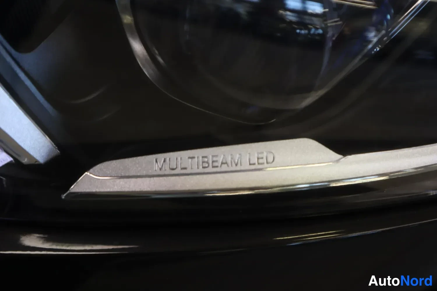 Yksityiskohta: Makrokuva etupäässijaitsevan ajovalon merkinnästä MULTIBEAM LED mustassa pinnassa.