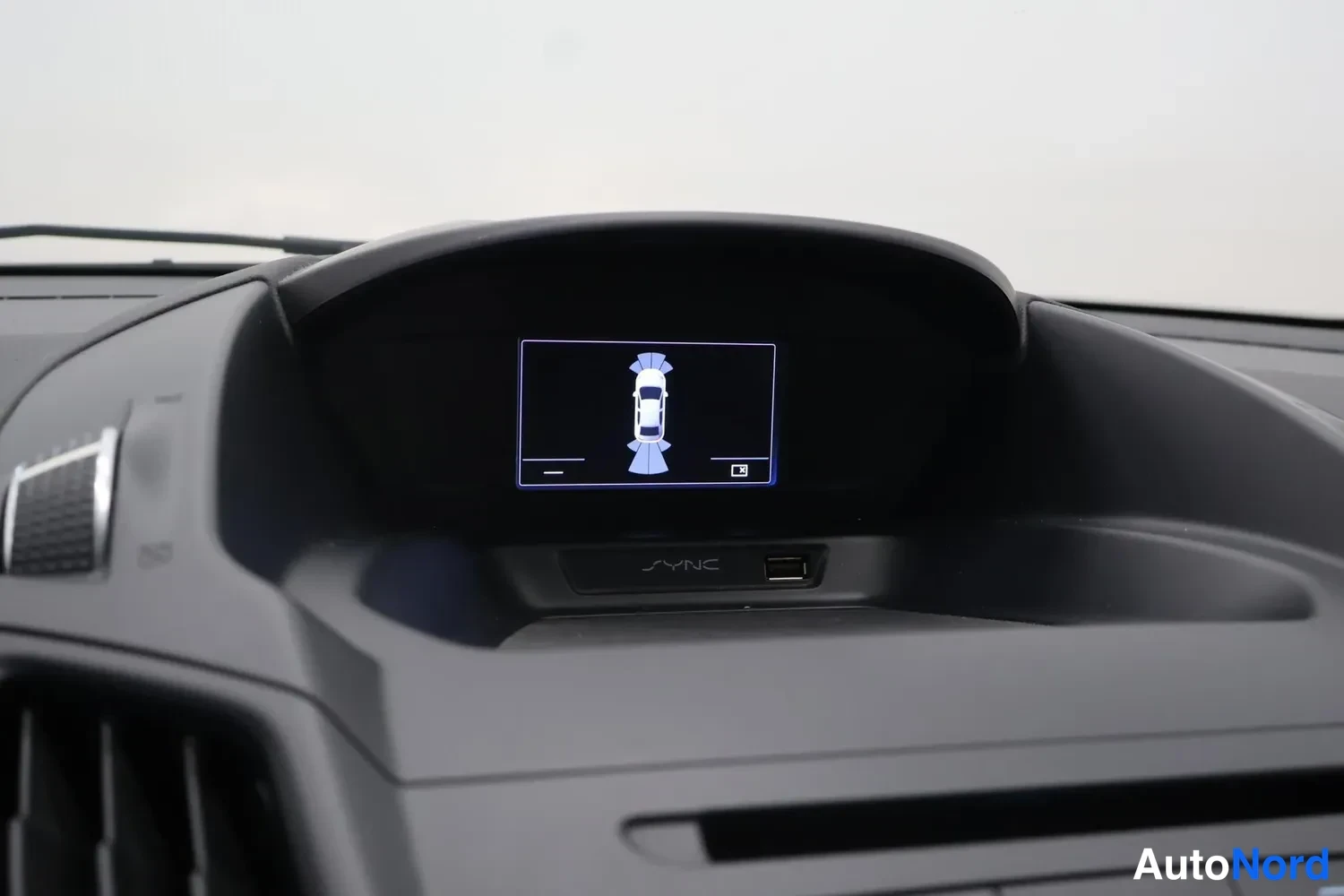 Muu: Kojelaudan näyttö, jossa näkyy auton kuva ja ilmastointia kuvaava grafiikka; SYNC-merkintä ja USB-portti näytön alla.
