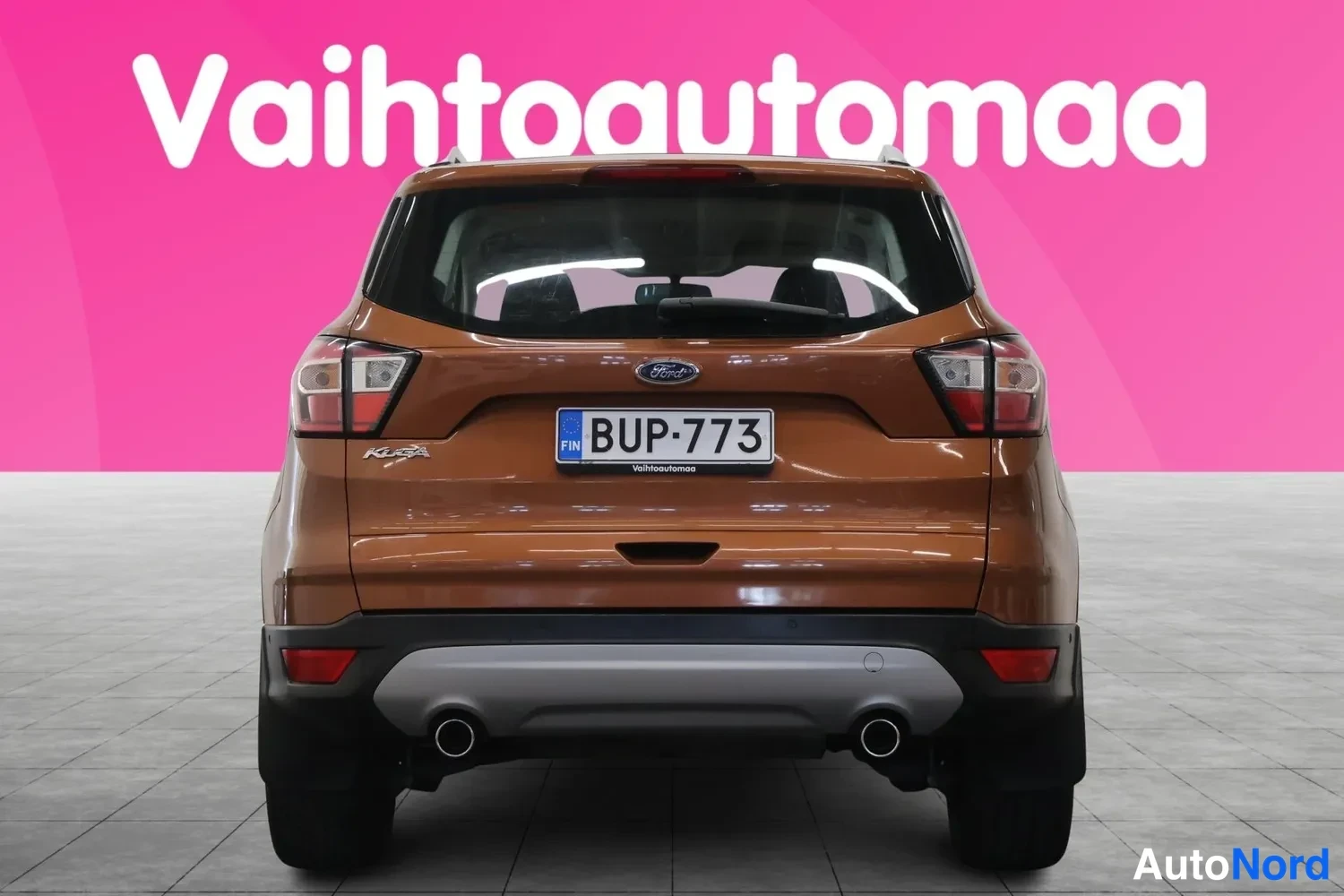 Takaa: Ford Kugan takaosa suoraan takaa, rekisterikilpi, kaksi pakoputkea ja Ford-merkki näkyvät.