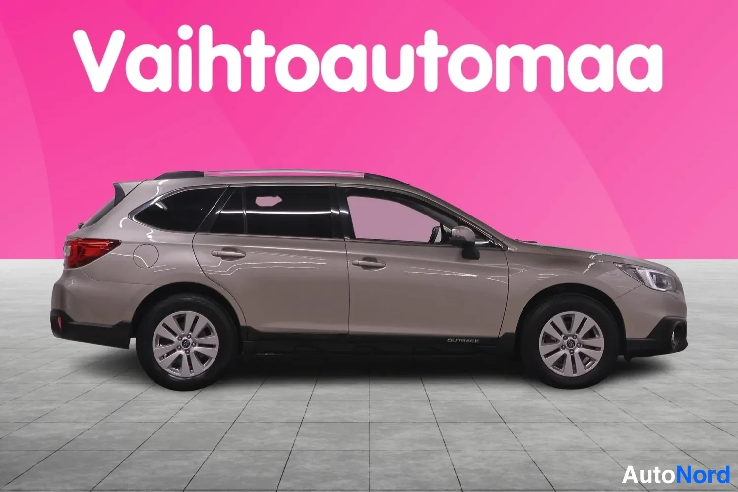 Etuviisto, nokka oikealle: Asema-auto sivulta kolmasosa-kulmassa, keula oikealla; kattoikuna ja OUTBACK-teksti ovessa.