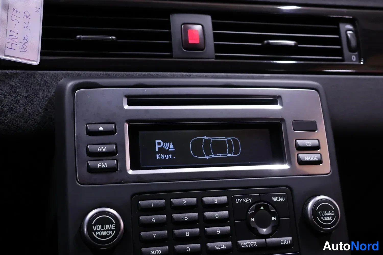 Muu: Autoon kytketty radio/kasettisoitin: näytössä tekstit P Käyt. ja telinepysäköintitunnus, alapuolella numeronäppäimistö, AM/FM-painikkeet sekä VOLUME/TUNING-säät