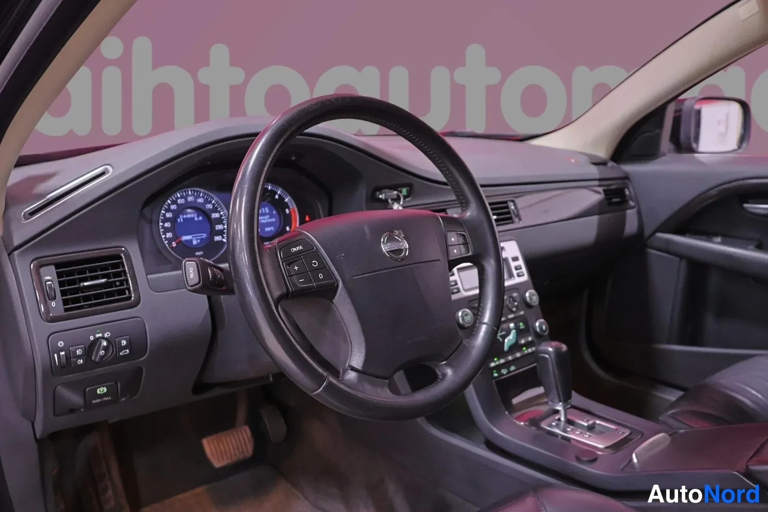Muu: Volvo-ohjauspyörä, mittaristo, kojelauta ja automaattivaihteen vaihdevipu. Ratti CRUISE- ja -/+-painikkeet. Mukana radiovaaka taustalla; kuva sisätilasta.
