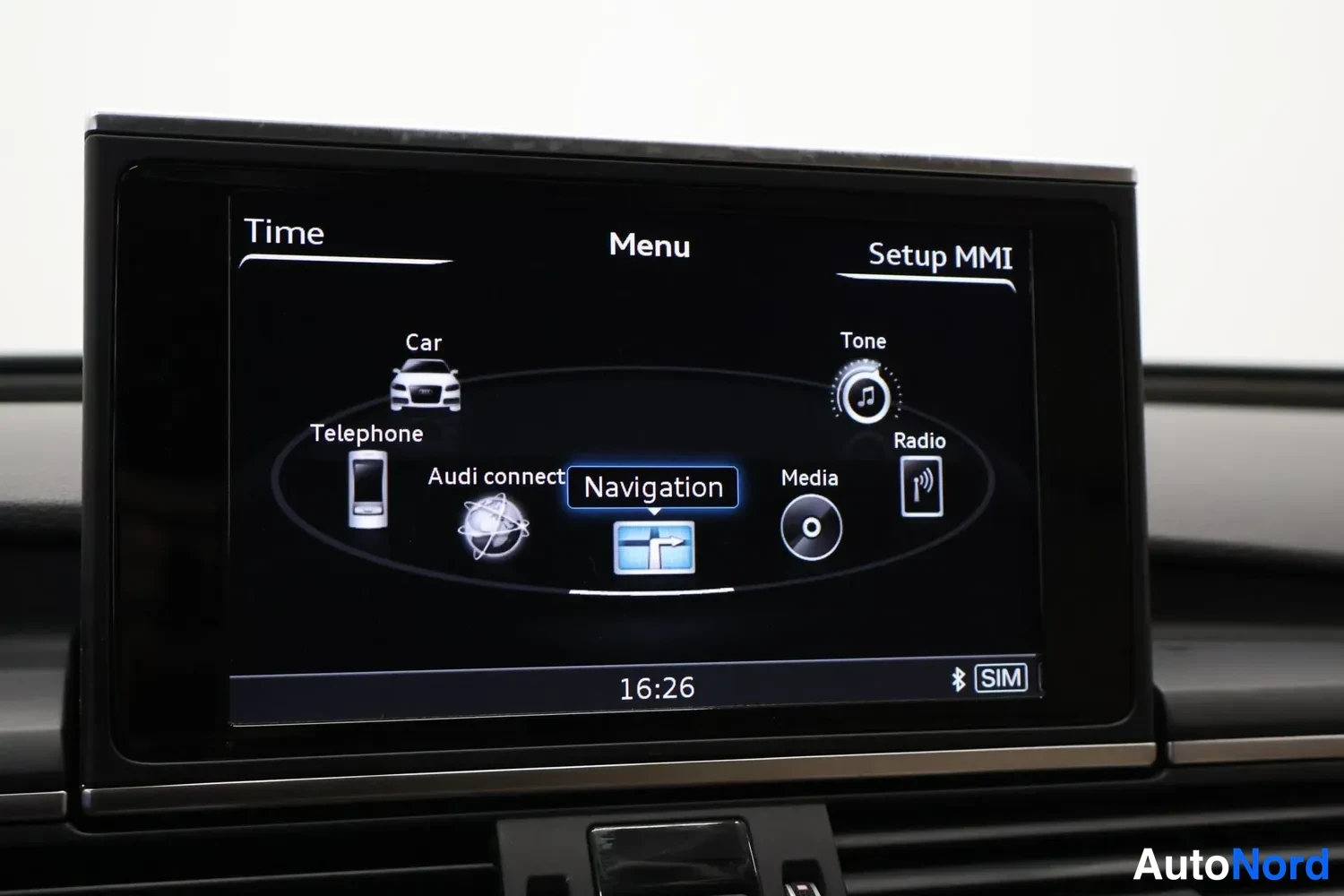 Muu: Audi MMI-näyttö valikossa: valikossa Car, Telephone, Audi connect, Navigation (valittu), Media, Radio, Tone, kello 16:26 ja SIM-merkintä.