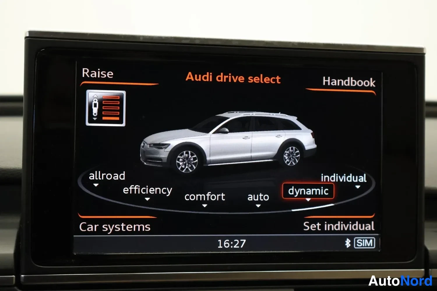 Yksityiskohta: Autoin päällä: MMI-näyttö, jossa Audi drive select -valikko. Ajoasetukset allroad, efficiency, comfort, auto, dynamic (valittu) ja individual. Kellonaika 16:27.