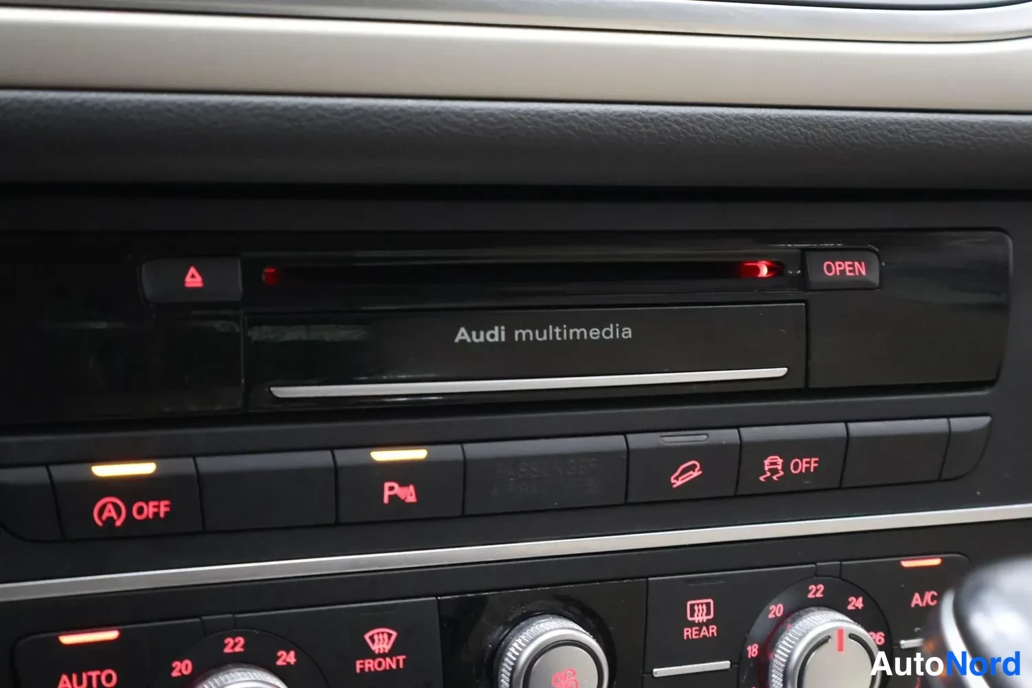 Yksityiskohta: Kojelauti, jossa Audi multimedia -yksikkö ja ilmastoinnin A OFF, P, OFF ja A/C -painikkeet.