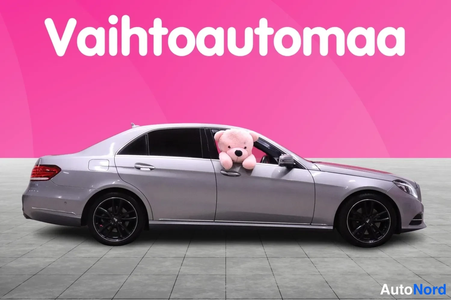 Sivulta: The side profile of the car is shown against a pink background.