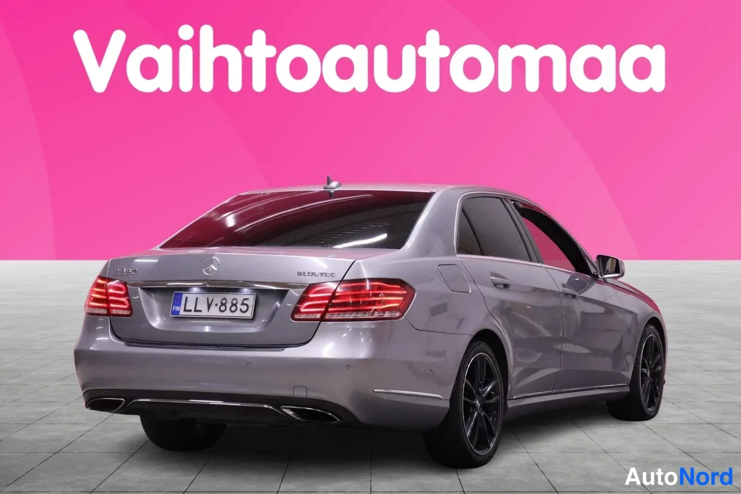 Takaviisto: Rear face with tail lights and trunk lid visible. Both rear flanks are partially visible behind the rear pillar, forming a rear three-quarter angle.