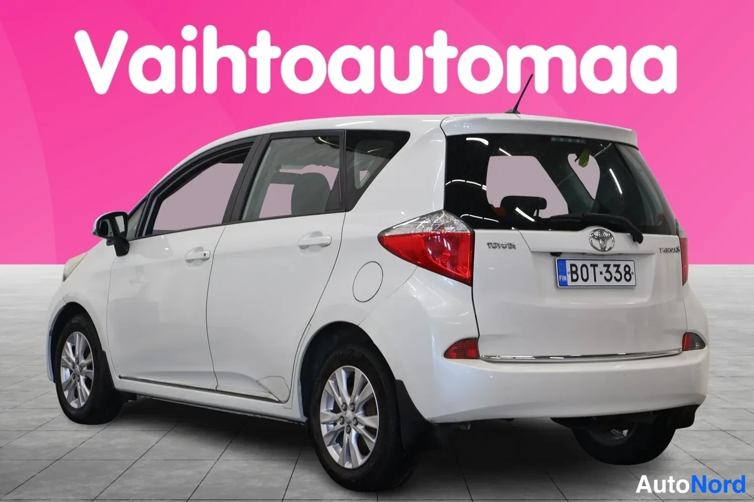 Takaviisto: Valkoinen Toyota Verso-S takaviistosta kuvattuna, rekisterikilpi.
