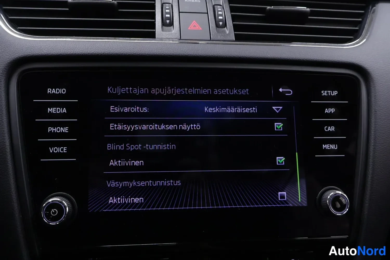 Muu: Kojelaudan näyttö, jossa apujärjestelmien asetukset: Blind Spot -tunnistin aktiivinen ja väsymystunnistus valittuna.