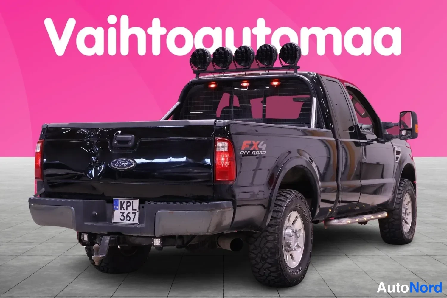 Takaviisto: Musta Ford-nippuavolava takaa viistosta; rekisteritunnus, kattoteline pyöräilyvaloilla ja FX4 Off Road -tarra lavan sivulla.