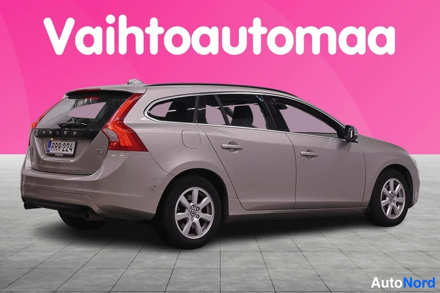 Takaviisto: Volvo V60 farmari takaa sivusta, rekisterikilpi, beigenharmaa koriväri.