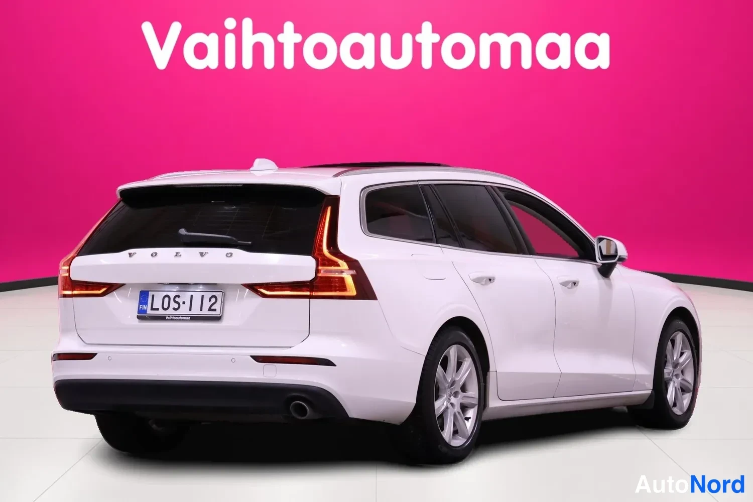 Takaviisto: Valkoinen farmariauto taka­viistolta oikealta, takavalot ja rekisteritunnus näkyvissä