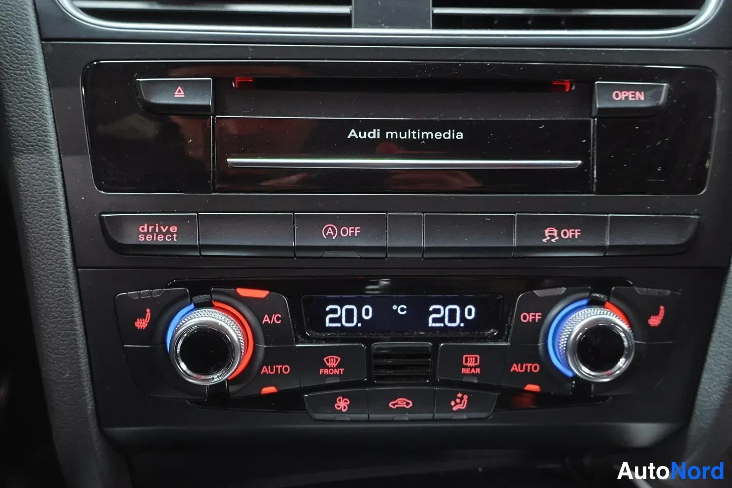 Edestä: Audi A5:n keskikonsoli, jossa Audi multimedia -yksikkö, drive select -painike, kaksivyöhykelämmitys ja A/C-asetukset.
